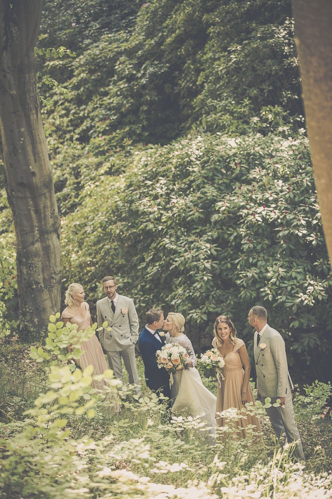 bröllopsfotograf med brudsällskapet i parken